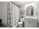 Enjoy this bathroom with a modern curved mirror, vanity, shower with gray striped curtain at 5605 Miners Rdg, Cumming, GA 30028