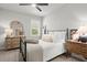 Bright bedroom featuring a metal bed frame, plush bedding, and wooden dresser with decorative mirror at 5605 Miners Rdg, Cumming, GA 30028