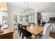 Spacious dining area with wood table, modern lighting and a view to the fireplace at 5605 Miners Rdg, Cumming, GA 30028