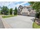 Two-story house with a wide driveway and garage, also featuring a basketball hoop and a manicured green lawn at 5605 Miners Rdg, Cumming, GA 30028