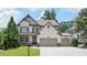 Charming two-story home with a manicured lawn, featuring a two-car garage and inviting front porch at 5605 Miners Rdg, Cumming, GA 30028