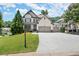 Charming two-story home with a well-manicured lawn, a driveway, and a basketball hoop near the garage at 5605 Miners Rdg, Cumming, GA 30028