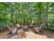 Backyard fire pit area surrounded by mature trees, perfect for outdoor entertaining at 5605 Miners Rdg, Cumming, GA 30028