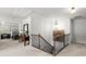 Upstairs hallway with decorative railing, open view to bedroom, and accent furniture at 5605 Miners Rdg, Cumming, GA 30028