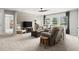 Open living space has plank accent wall, ceiling fan, large windows, and a comfortable seating area at 5605 Miners Rdg, Cumming, GA 30028