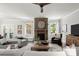 Spacious living room featuring modern fan, stone fireplace and lots of natural light at 5605 Miners Rdg, Cumming, GA 30028