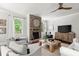 Bright living room with hardwood floors, fireplace, large windows and neutral furniture at 5605 Miners Rdg, Cumming, GA 30028