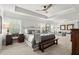 Spacious primary bedroom with tray ceiling, ceiling fan, complemented by stylish furnishings at 5605 Miners Rdg, Cumming, GA 30028