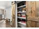 Pantry with rustic barn door shelving filled with games, food, and storage items at 5605 Miners Rdg, Cumming, GA 30028