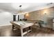 Recreation area with a light brick wall and pool table illuminated by three hanging lights at 5605 Miners Rdg, Cumming, GA 30028
