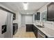 Modern kitchen boasts dark cabinetry, stainless steel appliances, granite countertops, and tile flooring at 1050 Chapman Circle Cir, Stone Mountain, GA 30088