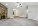 Bright living room with stone fireplace, soft carpet, and a ceiling fan at 1050 Chapman Circle Cir, Stone Mountain, GA 30088