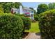 Wood bridge entrance through mature hedge showing house, deck and lush lawn and landscape at 130 Hamilton Way, Roswell, GA 30075