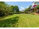 Lush backyard featuring manicured lawn and trees at 130 Hamilton Way, Roswell, GA 30075