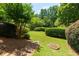 Lush backyard featuring landscaped hedges and mature trees creating a private, park-like setting at 130 Hamilton Way, Roswell, GA 30075