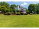 Expansive backyard with a deck featuring a red umbrella, and mature landscaping providing privacy at 130 Hamilton Way, Roswell, GA 30075