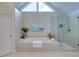 Modern bathroom featuring a soaking tub, glass enclosed shower and a bright triangular window at 130 Hamilton Way, Roswell, GA 30075