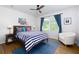 Bright bedroom features a ceiling fan, hardwood floors, and natural light at 130 Hamilton Way, Roswell, GA 30075