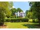 Backyard featuring a bocce court with stone edging, lush green lawn, trees and the home at 130 Hamilton Way, Roswell, GA 30075