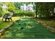 Bocce court and backyard featuring a chair under trees with home and deck visible in the background at 130 Hamilton Way, Roswell, GA 30075