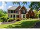 Charming two-story red brick home featuring a landscaped yard and welcoming front porch at 130 Hamilton Way, Roswell, GA 30075