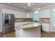 Bright kitchen features a stainless steel refrigerator, granite countertops and a tiled backsplash at 130 Hamilton Way, Roswell, GA 30075