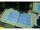 Aerial view of tennis courts that feature well-maintained surface with lighting and surrounding greenery at 130 Hamilton Way, Roswell, GA 30075