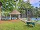 Community tennis courts featuring shaded picnic area and benches with a picnic table for relaxing and socializing at 130 Hamilton Way, Roswell, GA 30075