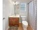 Well-maintained bathroom features a vanity with storage, a toilet, and a shower with a decorative curtain at 1525 Lake Dow Rd, Mcdonough, GA 30252