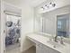 Well-lit bathroom featuring white vanity and a decorative shower curtain at 1525 Lake Dow Rd, Mcdonough, GA 30252