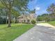 Charming two-story home with a well-manicured lawn, mature trees, and a long driveway at 1525 Lake Dow Rd, Mcdonough, GA 30252
