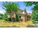 Beautiful brick home featuring a screened porch, lush landscaping, and mature trees in the backyard at 2317 Whiting Bay Courts Nw, Kennesaw, GA 30152