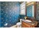 Stylish powder room featuring patterned wallpaper, elegant fixtures, and a marble-topped vanity at 2317 Whiting Bay Courts Nw, Kennesaw, GA 30152