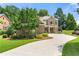 Charming brick home with manicured lawn, mature trees, and a circular driveway at 2317 Whiting Bay Courts Nw, Kennesaw, GA 30152