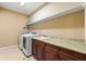 Well-equipped laundry room features a full-size washer, dryer and custom wood cabinetry at 2317 Whiting Bay Courts Nw, Kennesaw, GA 30152