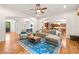 Open-concept living room with hardwood floors, modern rug, and seamless flow to the kitchen and dining area at 2317 Whiting Bay Courts Nw, Kennesaw, GA 30152