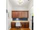 Well-lit office featuring custom wooden cabinets and drawers built into the wall with a bright modern light fixture at 2317 Whiting Bay Courts Nw, Kennesaw, GA 30152