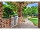 Outdoor stainless steel grill in brick surround with stone accents overlooks the community playground at 2317 Whiting Bay Courts Nw, Kennesaw, GA 30152
