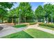 Well-maintained community playground area with slides and covered play structures surrounded by lush greenery at 2317 Whiting Bay Courts Nw, Kennesaw, GA 30152