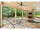 Relaxing screened porch with stone flooring, brick fireplace, ceiling fans, and views of the landscaped backyard at 2317 Whiting Bay Courts Nw, Kennesaw, GA 30152