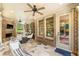 Cozy screened in porch with brick fireplace, ceiling fans, and comfortable seating; perfect for relaxing outdoors at 2317 Whiting Bay Courts Nw, Kennesaw, GA 30152
