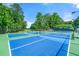 Outdoor tennis courts with pristine blue surface, surrounded by lush landscaping at 2317 Whiting Bay Courts Nw, Kennesaw, GA 30152