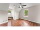 Bright bedroom featuring a ceiling fan, hardwood floors, and natural light from two windows at 2979 Overwood Sw Ln, Snellville, GA 30078