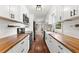 Modern galley kitchen with white cabinets, butcher block countertops, and stainless steel appliances at 2979 Overwood Sw Ln, Snellville, GA 30078