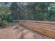 Back yard deck with built-in bench seating surrounded by mature trees at 502 Brookline Pl, Mcdonough, GA 30252