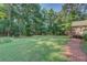 The home has a lush green backyard, a wooden deck, and a charming brick walkway through landscaped grounds at 502 Brookline Pl, Mcdonough, GA 30252