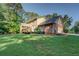 Home exterior featuring a large yard, back deck, brick facade, and attached garage at 502 Brookline Pl, Mcdonough, GA 30252