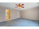 Carpeted bedroom includes ensuite bathroom entrance, neutral paint, and lighted ceiling fan at 502 Brookline Pl, Mcdonough, GA 30252