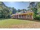 Charming one-story brick home featuring a welcoming front porch and a lush green lawn surrounded by mature trees at 502 Brookline Pl, Mcdonough, GA 30252