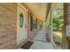 Covered front porch with brick columns, and a decorative oval window on the door at 502 Brookline Pl, Mcdonough, GA 30252